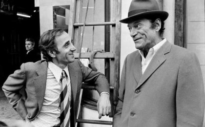 Charles Aznavour y Eddie Constantine conversan en una calle de París en noviembre de 1972 (AFP)