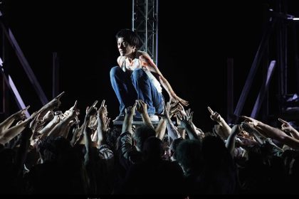 Plano general del Coro Titular del Teatro Real y actores rodeando a  Marion Cotillard (Juana de Arco)
