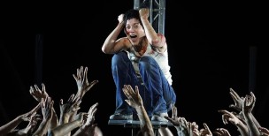 Plano general del Coro Titular del Teatro Real y actores rodeando a  Marion Cotillard (Juana de Arco)